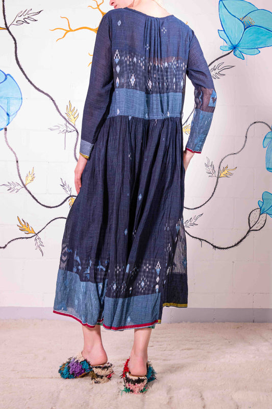 Model wearing pure cotton dress by Injiri – navy blue handloomed summer dress with jamdani weaving, contrast trim, long sleeves, and adjustable drawstring waist. Made from 100% organic cotton and handcrafted in India.