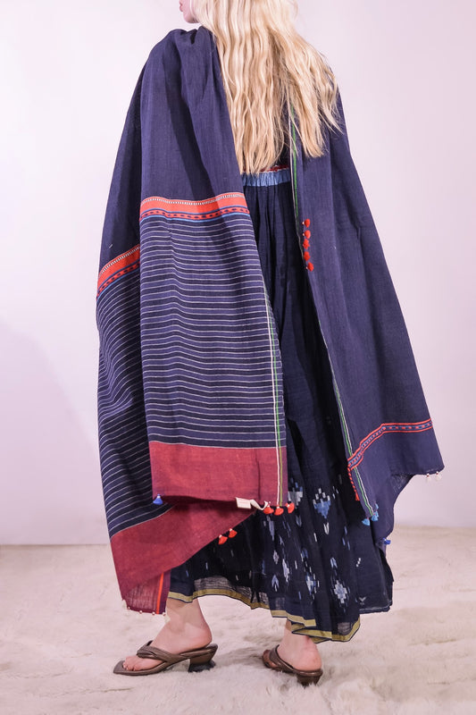 Model wearing pure cotton scarf by Injiri – handloomed unisex accessory in natural indigo with red and white woven details, crafted from organic cotton and finished with tassels. Ethically handmade in India