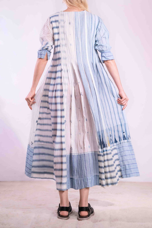 Woven wearing handcrafted pure cotton dress by Injiri in white with blue patterns and delicate embroidery, featuring short sleeves, side pockets, and a relaxed, airy silhouette. Available at House of Woven Stories.