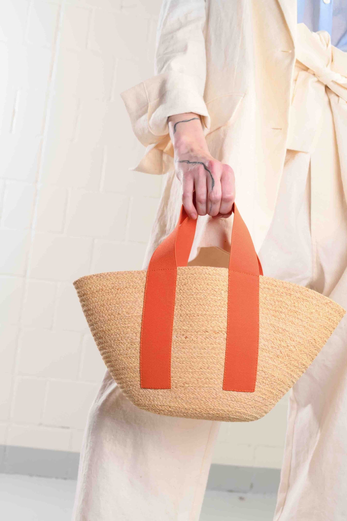 Carrot Mini Market raffia bag by Lola Hats with elastic handles and stitched raffia tape design. Available at House of Woven Stories.