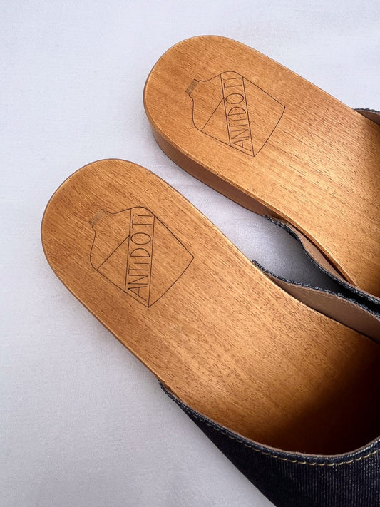 Handmade dark denim clogs by Antidoti with studded sides and wooden sole, crafted in Florence, Italy. Available at House of Woven Stories.