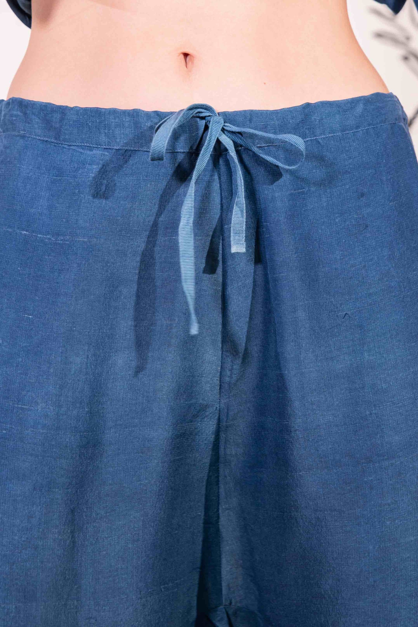 Model is wearing the Everyday Indigo Drawstring Pants with matching Cave Shirt, both in natural dyed silk by A Sacred Wrap. Handcrafted and botanically dyed, this look is available at House of Woven Stories.