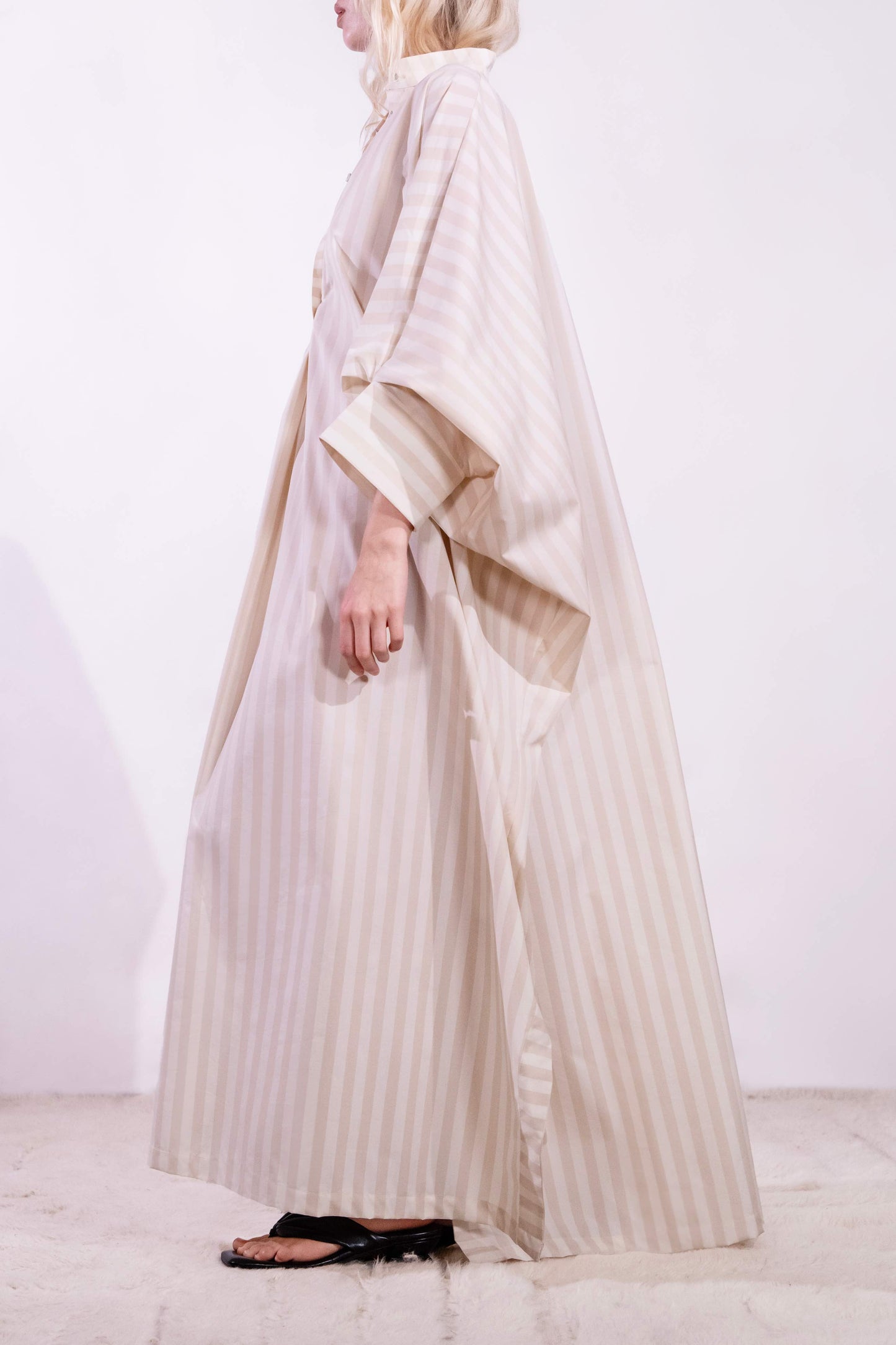 Model wearing the Fez striped shirt dress with batwing sleeves and button placket, handcrafted in Italy from 100% cotton by House of Woven Stories.