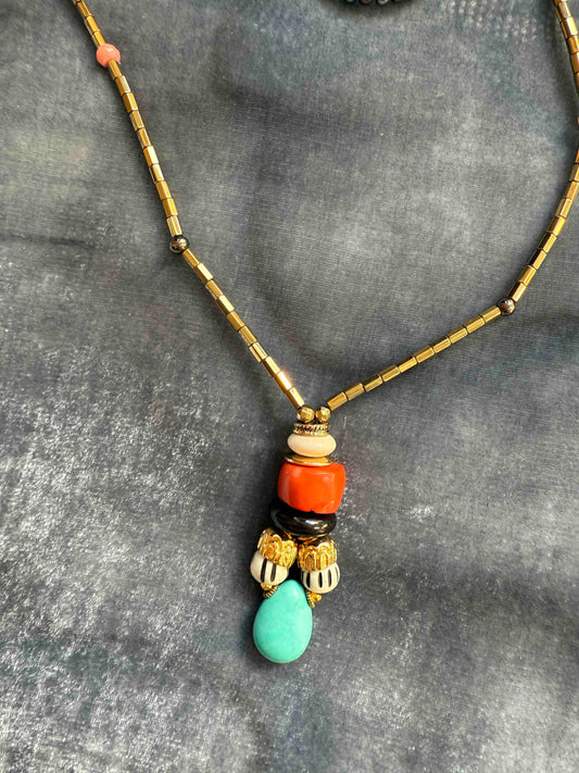 Striking handcrafted choker necklace with pyrite, pink bamboo coral, turquoise, bone inlay, and brass details. Made in Italy by Ilaria Fiorentini Jewellery. Part of the House of Woven Stories selection.