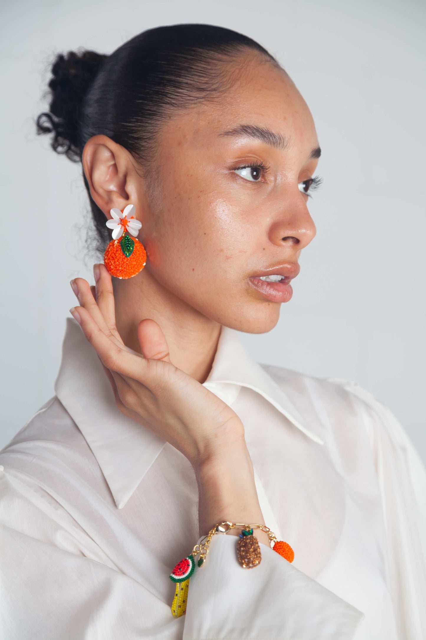 Hand-beaded orange earrings with seed beads and sequins, gold-plated brass posts, from Olivia Dar’s summer fruit collection.