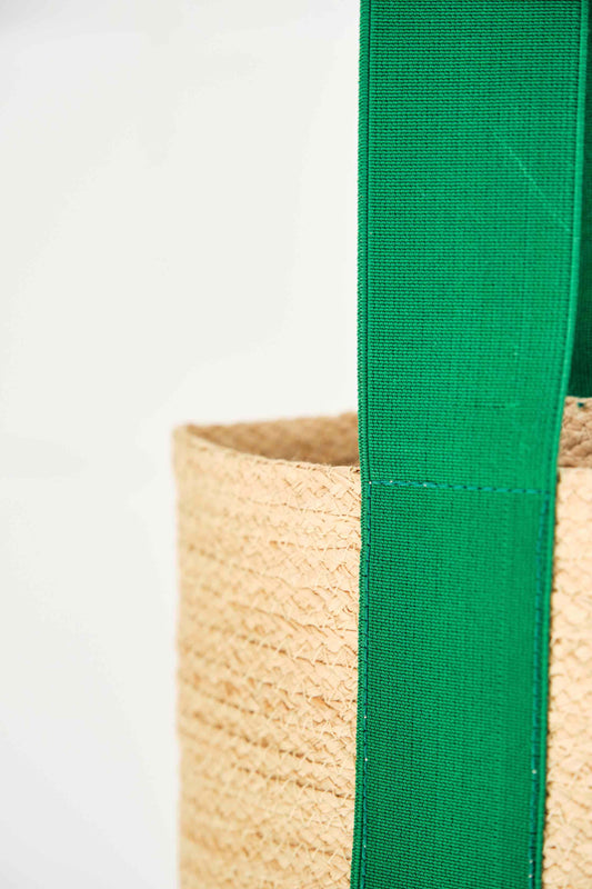 Green raffia Cornichon tote bag with emerald elastic straps and natural leather handle by Lola Hats. Part of House of Woven Stories selection.