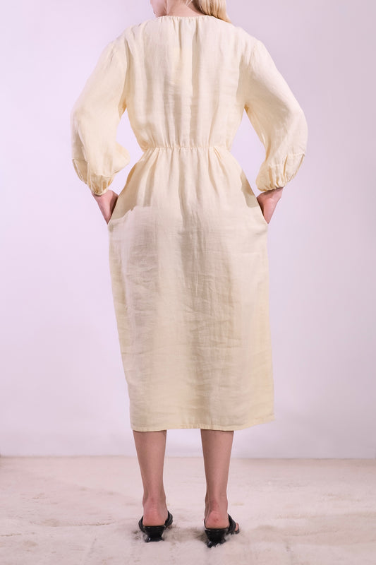 Model is wearing La Robe Bohème in banana yellow linen by Happy Haus - a timeless, feminine midi dress crafted from sustainable fabric with an effortless Parisian feel. Part of House of Woven Stories selection.