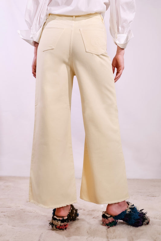 Model is wearing the Le Pantalon Oversize by Happy Haus. Wide-leg, regular-length cotton trousers with five pockets and wooden buttons, combining relaxed fit with eco-conscious design.