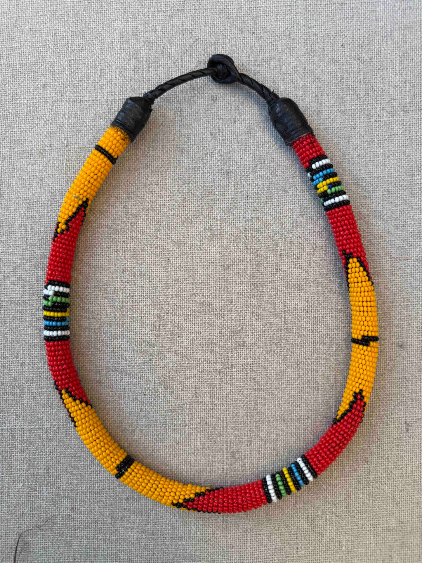 Multicolor beaded necklace handcrafted by Maasai women artisans in Kenya, featuring intricate glass beadwork. Curated by House of Woven Stories.
