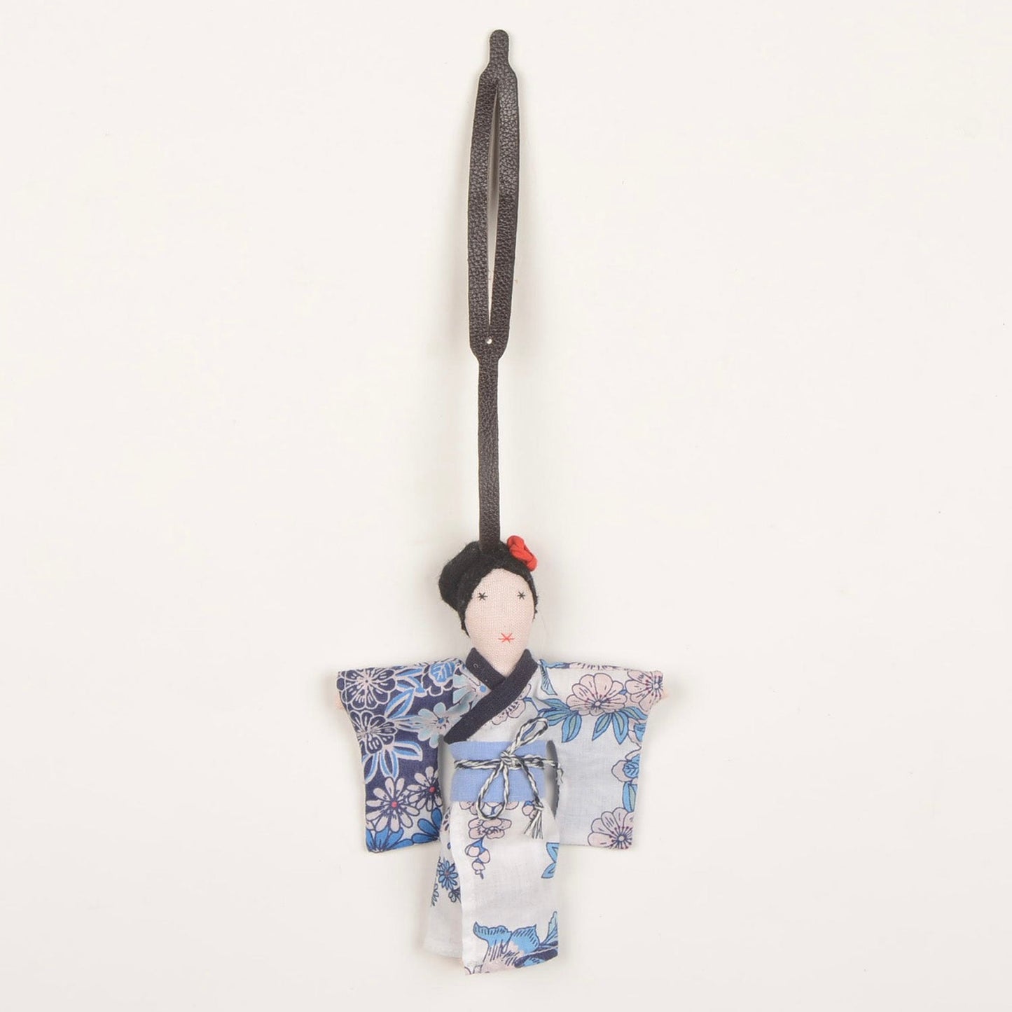 Mizu kimono fabric charm handcrafted by Afghan women artisans, shown attached to a bag, made from upcycled fabric with traditional kimono design and pink rose detail.