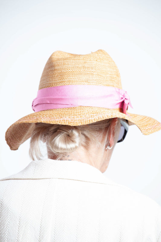 Natural straw-look paper hat with grosgrain ribbon by Lola Hats, handcrafted and adjustable for perfect fit. Available at House of Woven Stories.