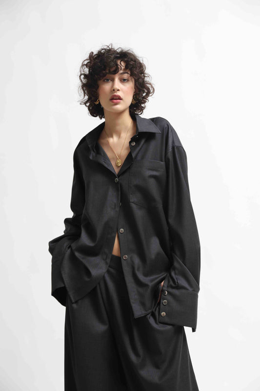 Model is wearing the Anthracite Oscar Shirt by House of Woven Stories, made from 100% Pure Merino Cool Wool with a classic collar and minimalist silhouette.