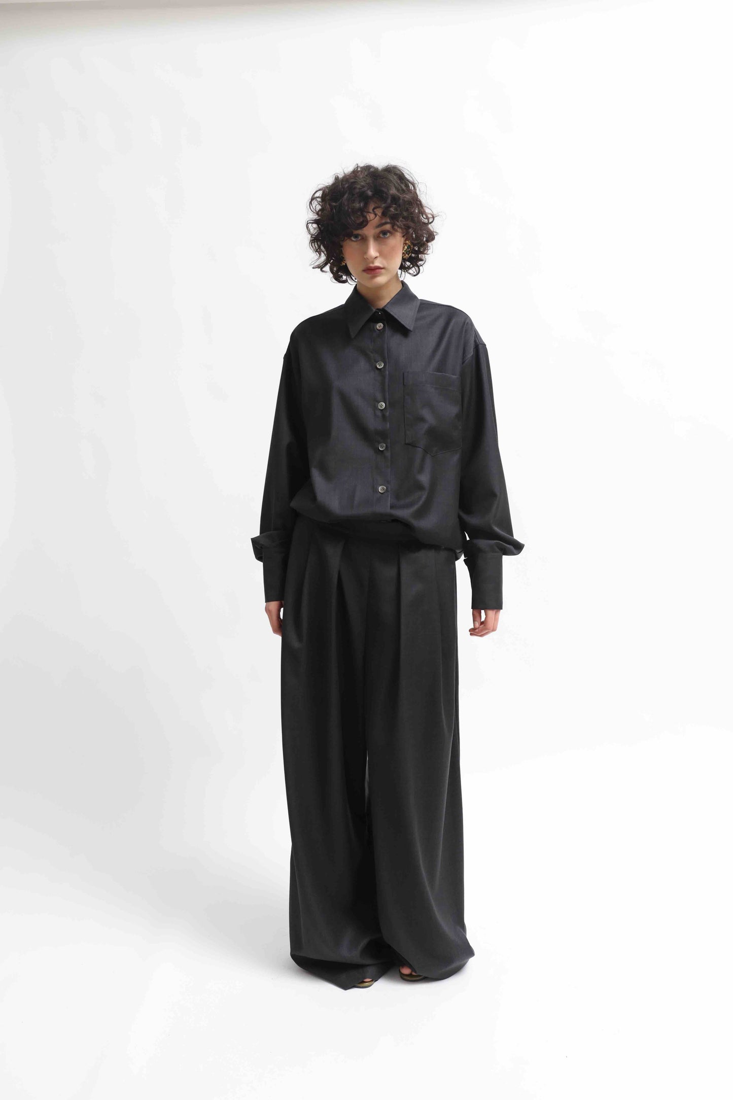 Wide-leg cool wool trousers in 100% Super 100 Pure Merino Wool with elastic waistband and front pleats, handmade in Italy by House of Woven Stories, shown in Anthracite.