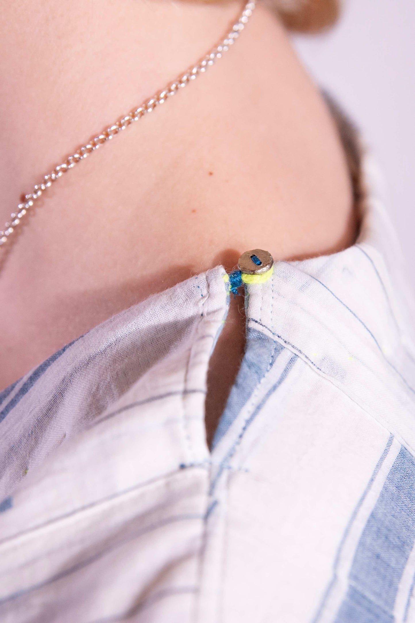 Woven wearing handcrafted pure cotton dress by Injiri in white with blue patterns and delicate embroidery, featuring short sleeves, side pockets, and a relaxed, airy silhouette. Available at House of Woven Stories.