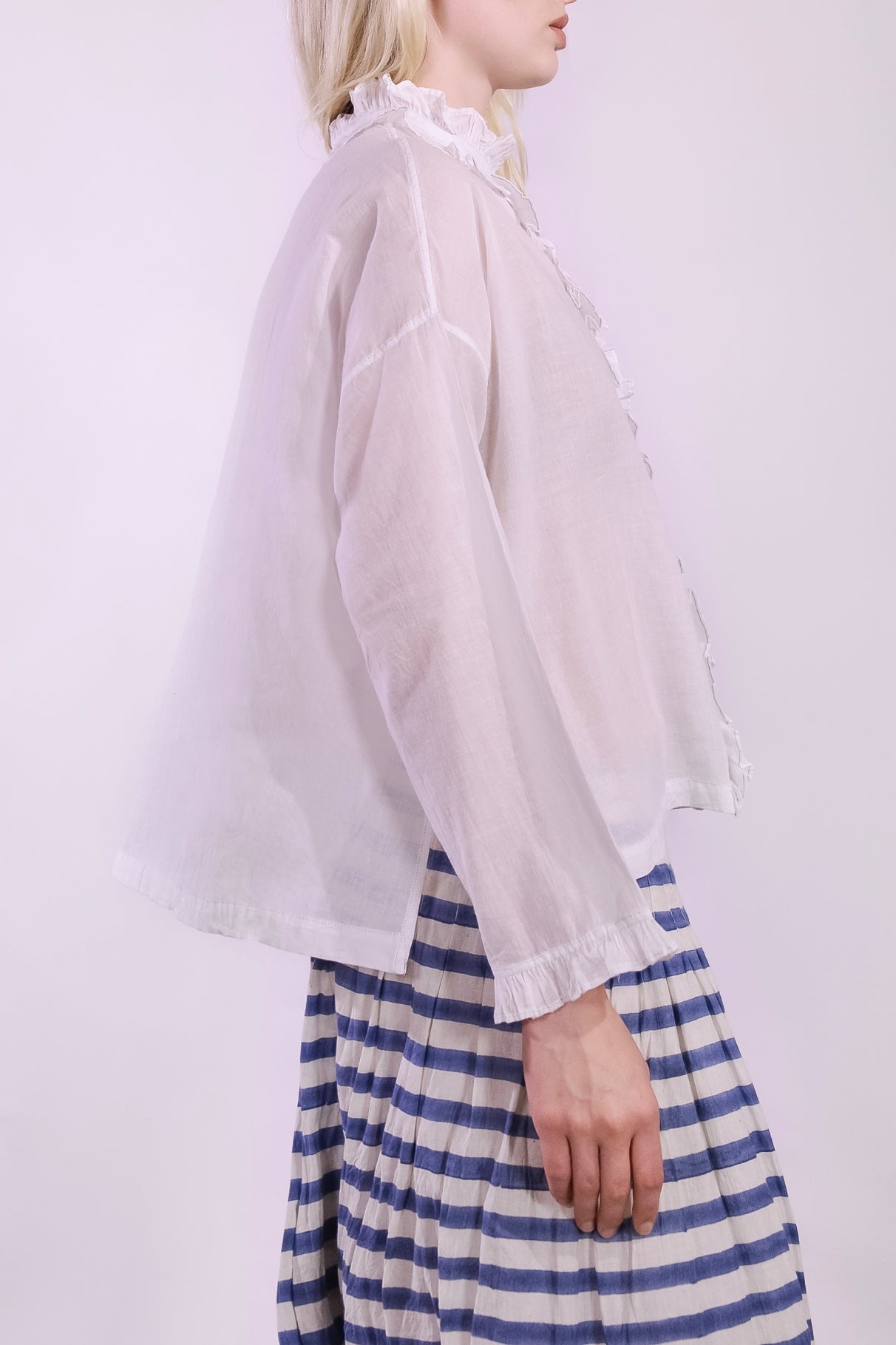White pure cotton shirt by Injiri with cobalt ruffle stitching and yellow buttons, handmade and sustainable. Available at House of Woven Stories.