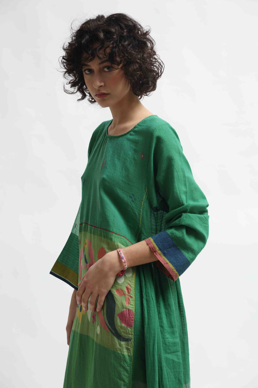 Model wearing the Rasa 01 midi dress by Injiri, handcrafted in India from pure cotton with delicate handprinted floral details on the lower half. Lightweight, artisanal, and timeless.