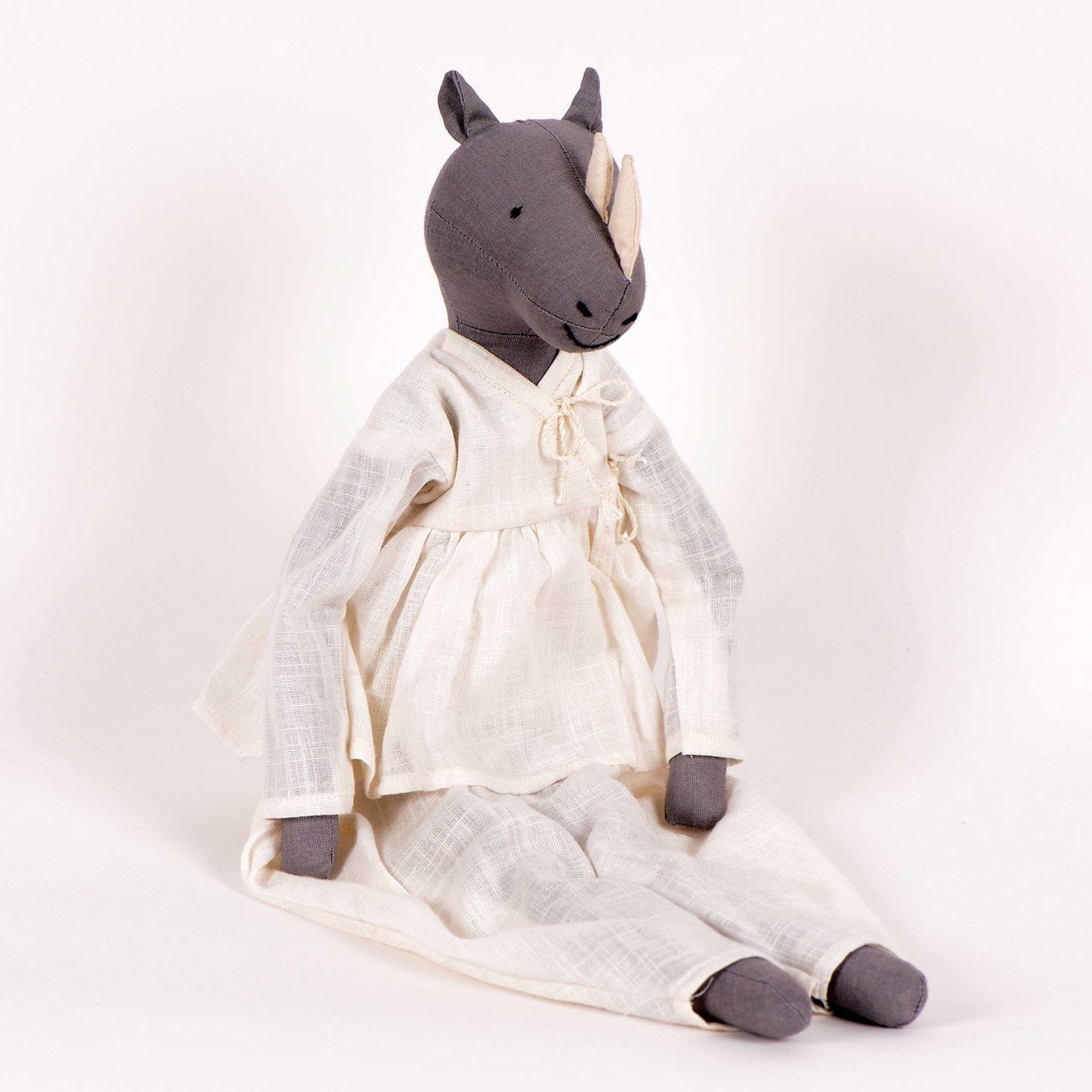 Ura handcrafted rhinoceros cloth doll made from upcycled fabric by SilaiWali, with bedding in foldable box. Available at House of Woven Stories.