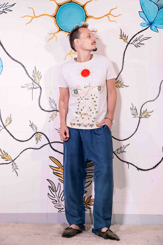 Artist Didè Comte wearing the Aria white hand-painted organic cotton T-shirt by House of Woven Stories, featuring her original artwork.