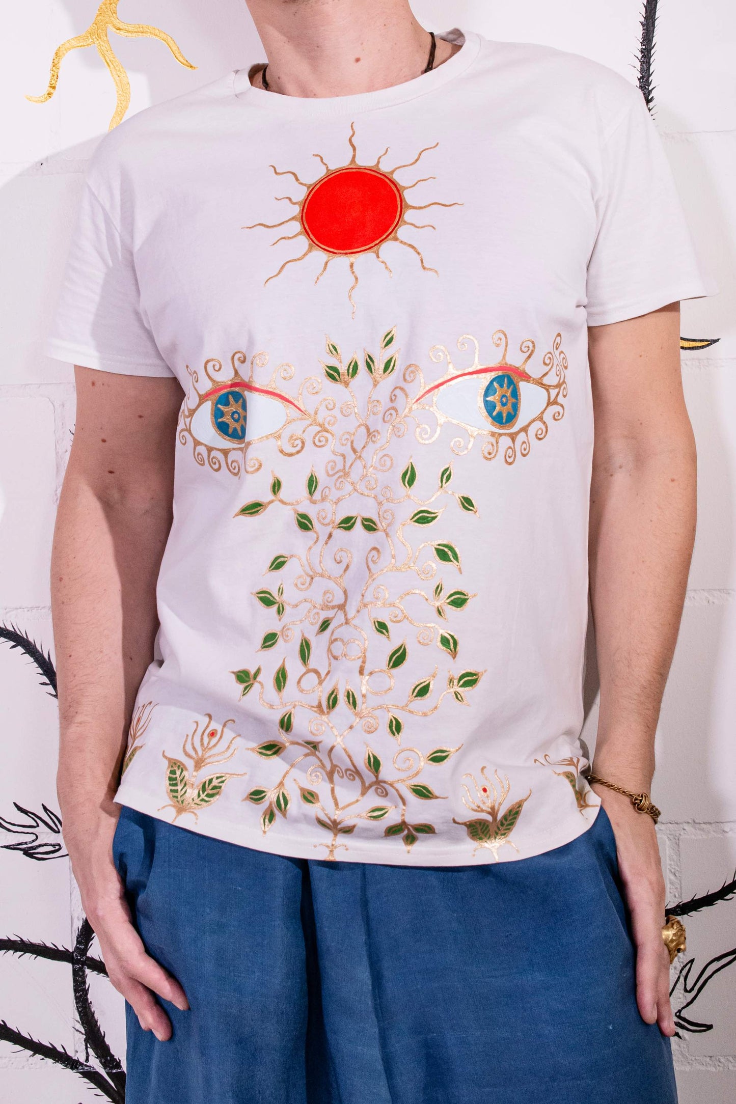 Artist Didè Comte wearing the Aria white hand-painted organic cotton T-shirt by House of Woven Stories, featuring her original artwork.