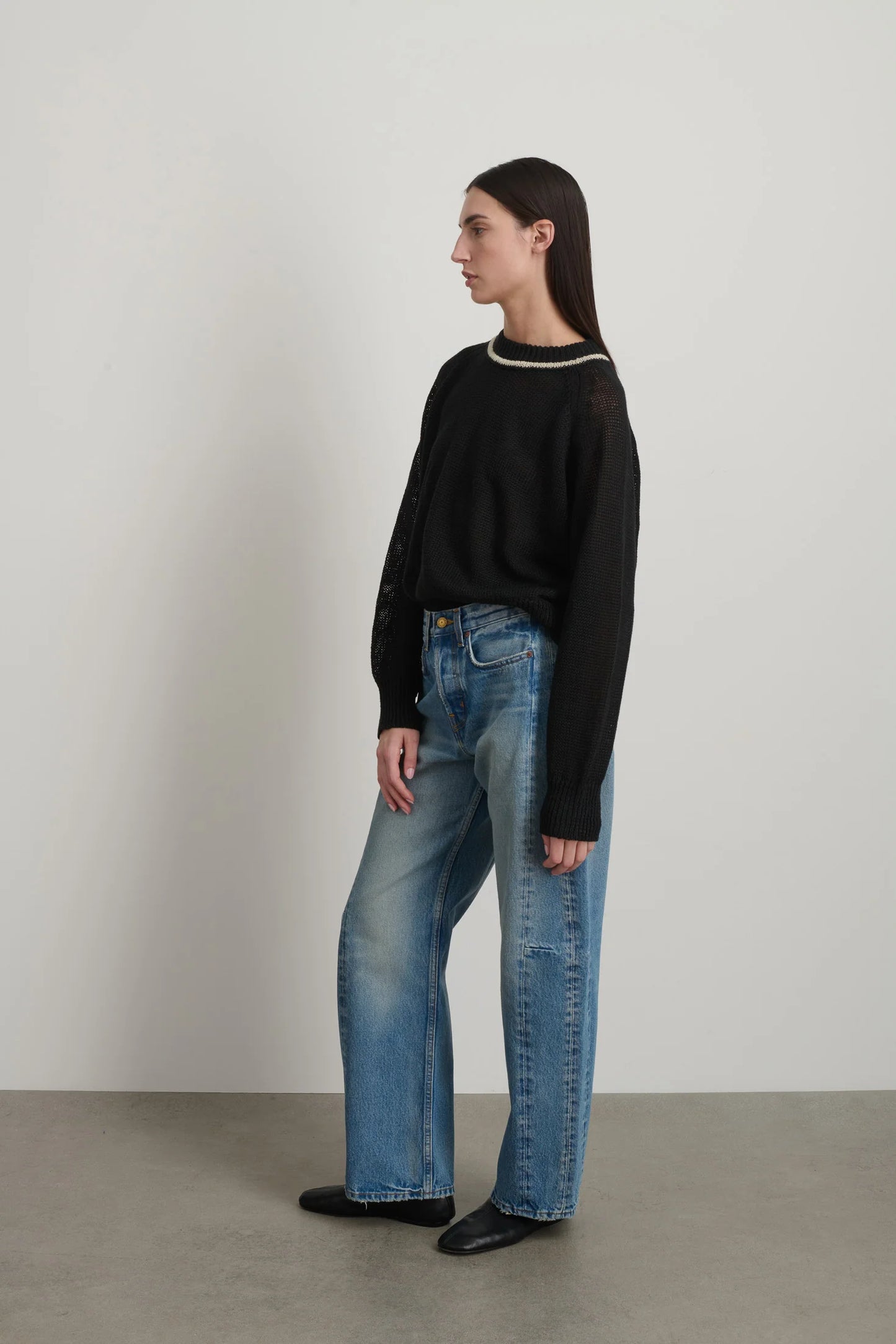 Model is wearing B Sides Slim Lasso Jean in vintage indigo denim, high-rise relaxed kinked leg jeans with 29-inch inseam, stone-washed mid-tone finish, from the curated selection of House of Woven Stories