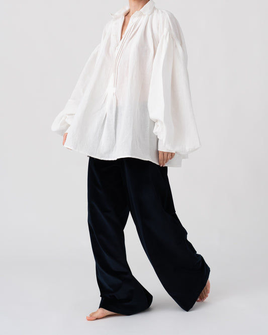Model is wearing the Carmen Blouse by Les Vacances d’Irina, a hand-stitched linen-cotton shirt with wide sleeves and square buttons, reimagining a traditional Romanian silhouette, available at House of Woven Stories.