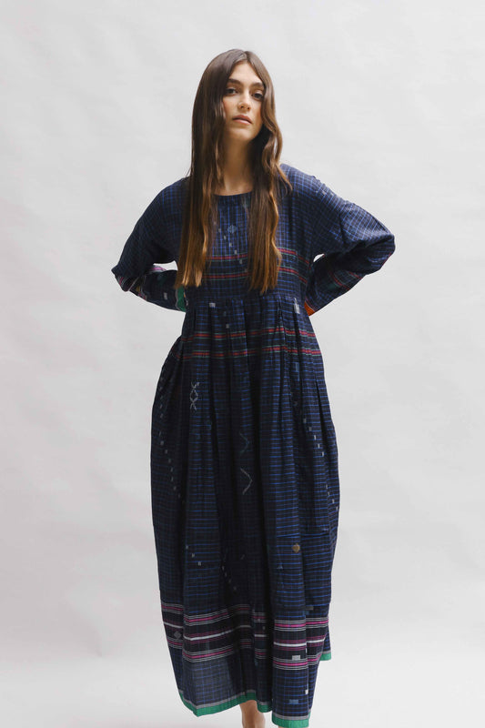 Model is wearing the Folklore 13 handmade silk dress by Injiri, featuring an empire waist, enamel buttons, and ribboned sleeves, artisan-made in India.