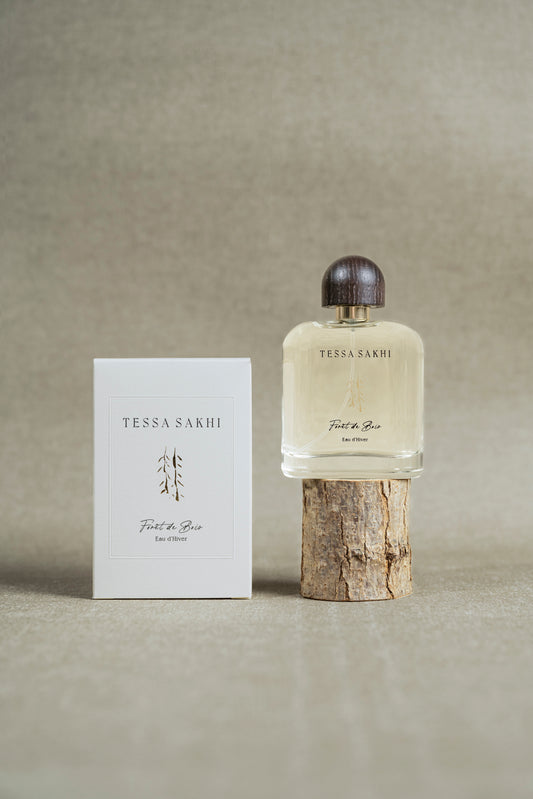 Bottle of Forêt de bois – Eau d’Hiver by Tessa Sakhi, a unisex woody and spicy Eau de Parfum with notes of juniper, cedar, tobacco, and ambergris. A sophisticated and mysterious fragrance curated by House of Nomad Stories.