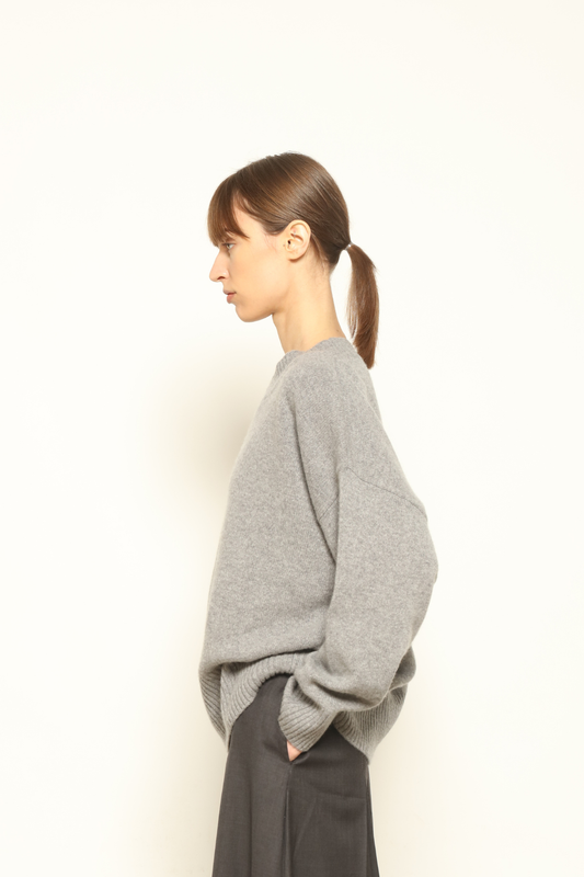 Model is wearing the graphite Noemi Round Neck Pullover by House of Woven Stories, crafted from 100% pure Inner Mongolia cashmere, featuring ultra-soft, breathable, durable knitwear, relaxed fit, round neckline, and timeless ethical luxury design