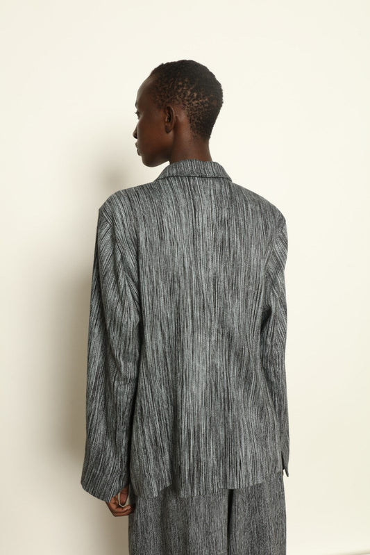 Model is wearing the Grey Chambray Blazer by Marrakshi Life, part of House of Nomad Stories collection, handwoven cotton blazer with relaxed fit, notched collar, and classic tailored details