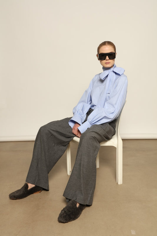 Model is wearing Grey Melange Parigi Wool Trousers by House of Woven Stories, part of the curated House of Woven Stories selection, crafted in Italy from soft cotton flannel with mid-rise waist, front pleats, and wide-leg silhouette for refined comfort.