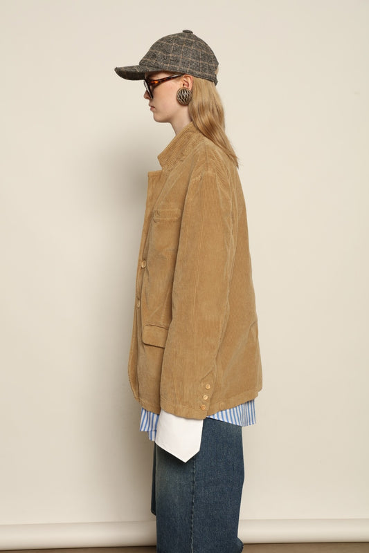 Model is wearing Le Blazer in Vintage Beige by Happy Haus, a GOTS-certified Italian corduroy cotton tailored jacket with relaxed straight silhouette, flap pockets, wooden buttons and soft back slit, curated in the House of Woven Stories selection.