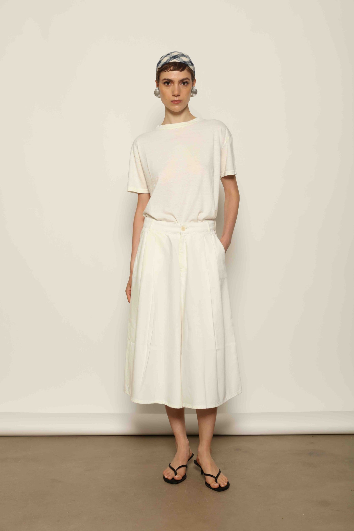 Model wearing the La Jupe Culotte in Blanc Cassè by Happy Haus from the House of Nomad Stories collection, featuring premium Japanese denim, a high-waisted fit, wide-leg silhouette, and elegant ankle-length design.