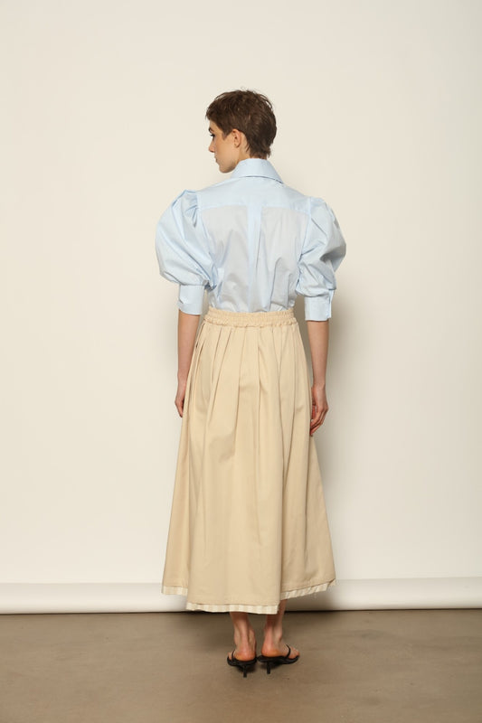 Model wearing the Karin Sky Blue Short Sleeves Blouse by House of Nomad Stories, featuring organic cotton fabric, sculptural balloon sleeves, structured silhouette, and a versatile neck tie detail.