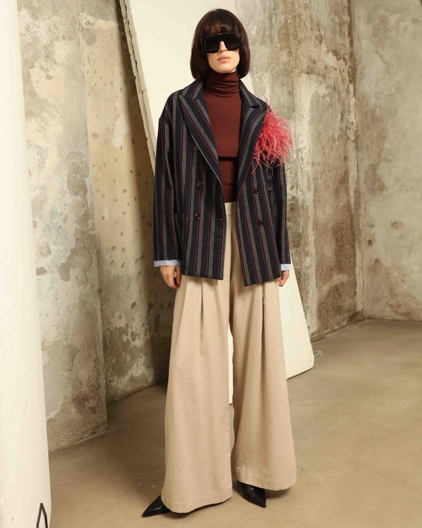 Model is wearing House of Woven Stories camel sweatpants, handmade in Italy with a relaxed fit and elasticated waist, crafted in sustainable luxury.