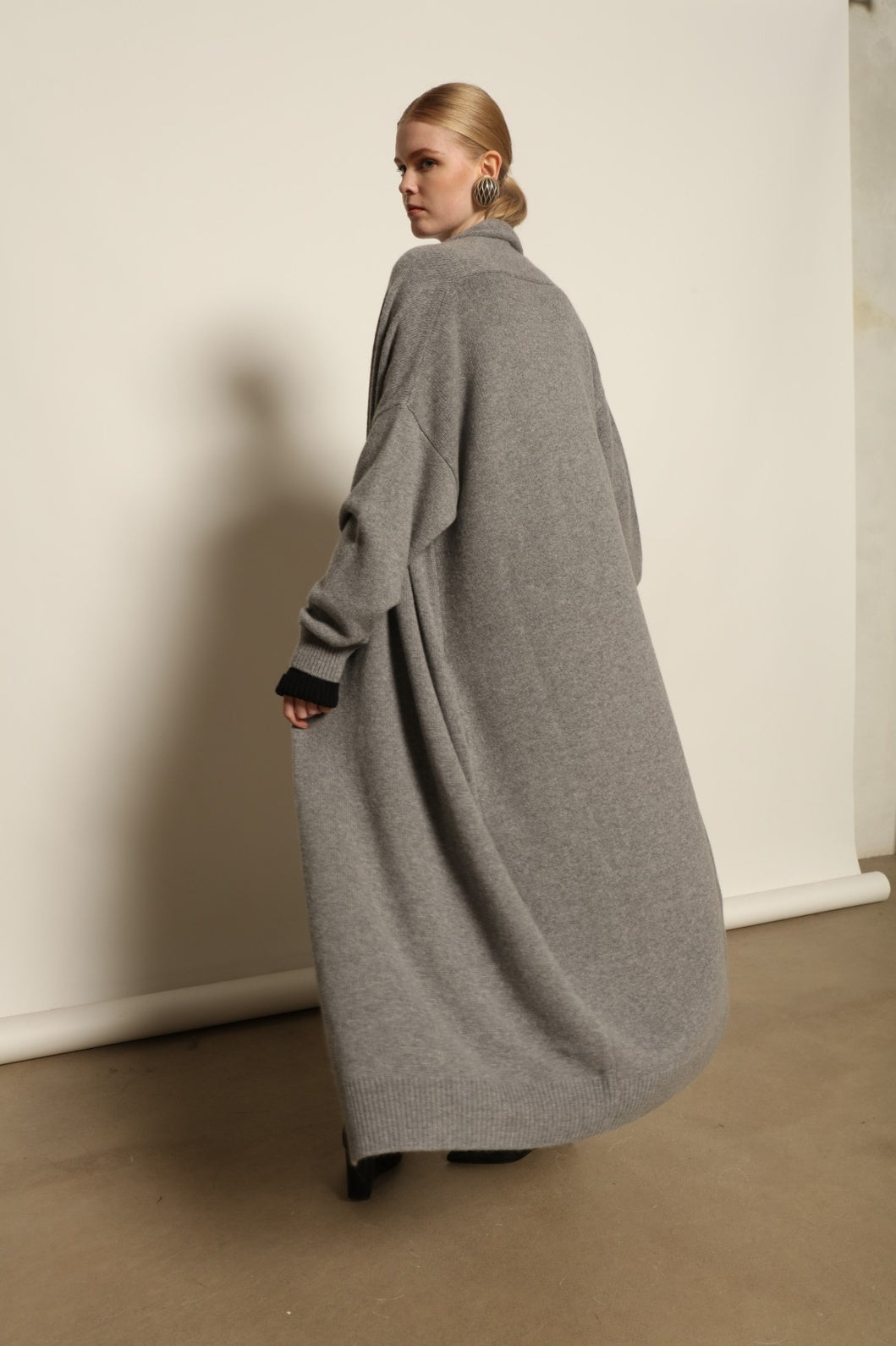 Model is wearing the Graphite Paula Cashmere Coat by House of Woven Stories, a pure ethically sourced cashmere coat in deep graphite with fluid open-front silhouette and refined soft drape.