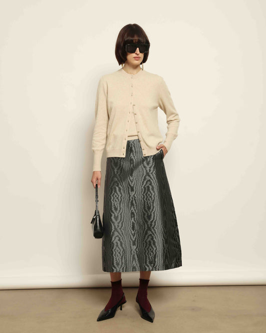 Model is wearing House of Woven Stories Nathalie Coreana Cardigan in natural undyed pure cashmere, long sleeves, round neckline, buttoned front, handmade in Italy with ultra-fine fibers from Inner Mongolia and Tibet.