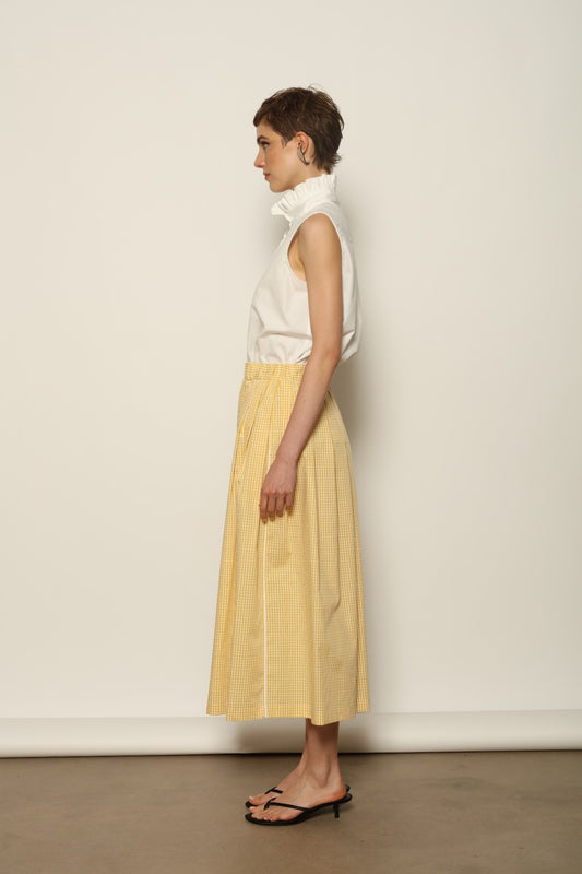 Model wearing the Seoul Vichy Butter Yellow Skirt by House of Woven Stories, featuring a butter yellow gingham pattern, draped silhouette, white piping waistband, and elegant summer design.