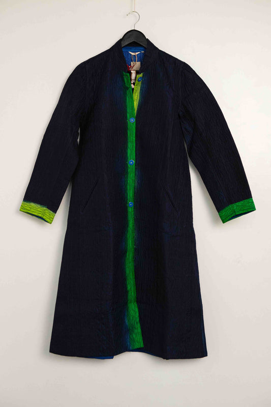 Model is wearing the Folklore 18 handmade silk coat by Injiri, featuring a navy blue exterior, green lining, 100% silk, and luxurious artisan craftsmanship.