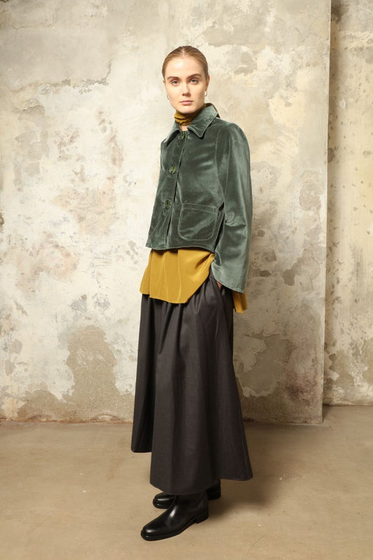 Model wearing Katharina Jacket in Velvet Green Cotton by House of Woven Stories, part of the curated selection, handcrafted in Italy from fine cotton velvet with hand-dyed shibori lining, expressing timeless elegance and artisanal craftsmanship.