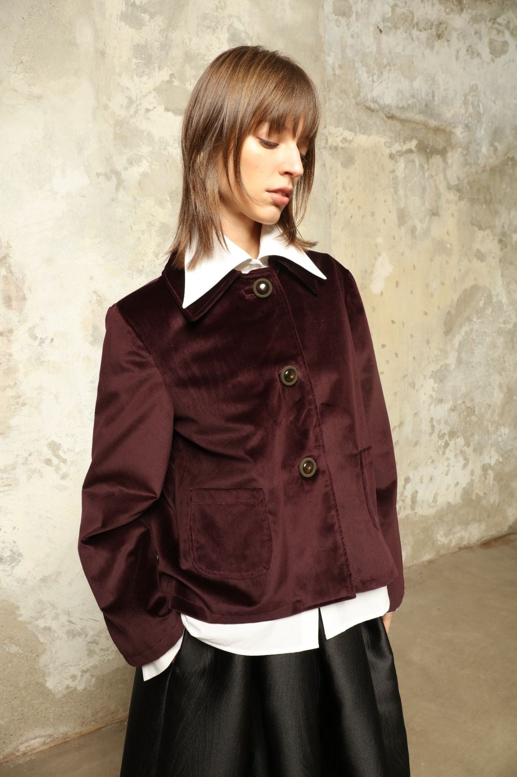 Model is wearing the Katharina Velvet Burgundy Cotton Jacket by House of Woven Stories, crafted from cotton velvet with an A-shape silhouette and hand-printed silk lining.