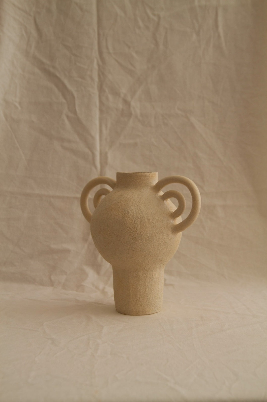 L’Enfant Lune aux Doubles Anses by Clandestine Céramique, handbuilt in sandy clay with double curving handles and soft glaze, part of the House of Woven Stories selection.