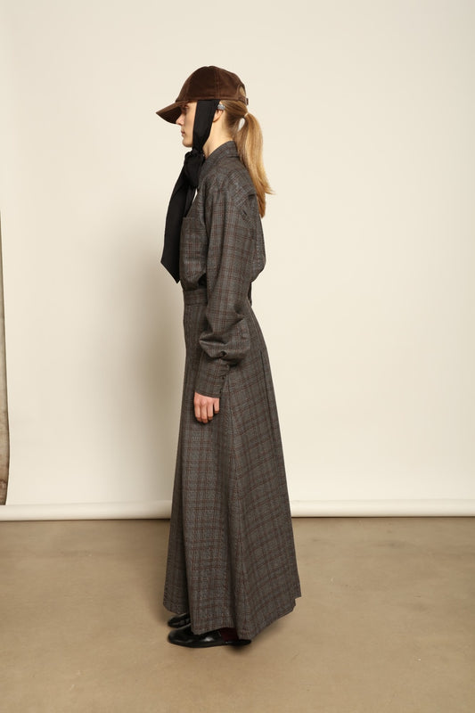 Model is wearing the Londra Brown Checked Skirt by House of Woven Stories, ankle-length with fine pleats and brown checked pattern, combining timeless tailoring with contemporary elegance and quality craftsmanship.