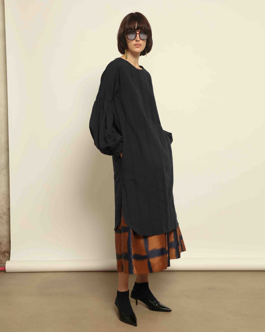 Model is wearing the Lulu Dress by House of Woven Stories in navy blue with voluminous sleeves, A-line silhouette.