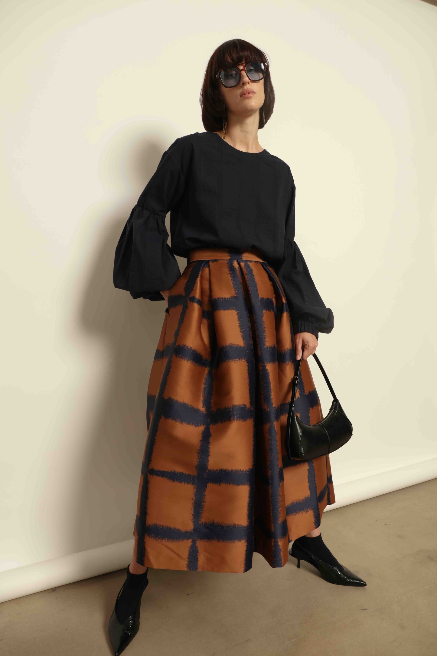 Model is wearing the Lulu Dress by House of Woven Stories in navy blue with voluminous sleeves, A-line silhouette.