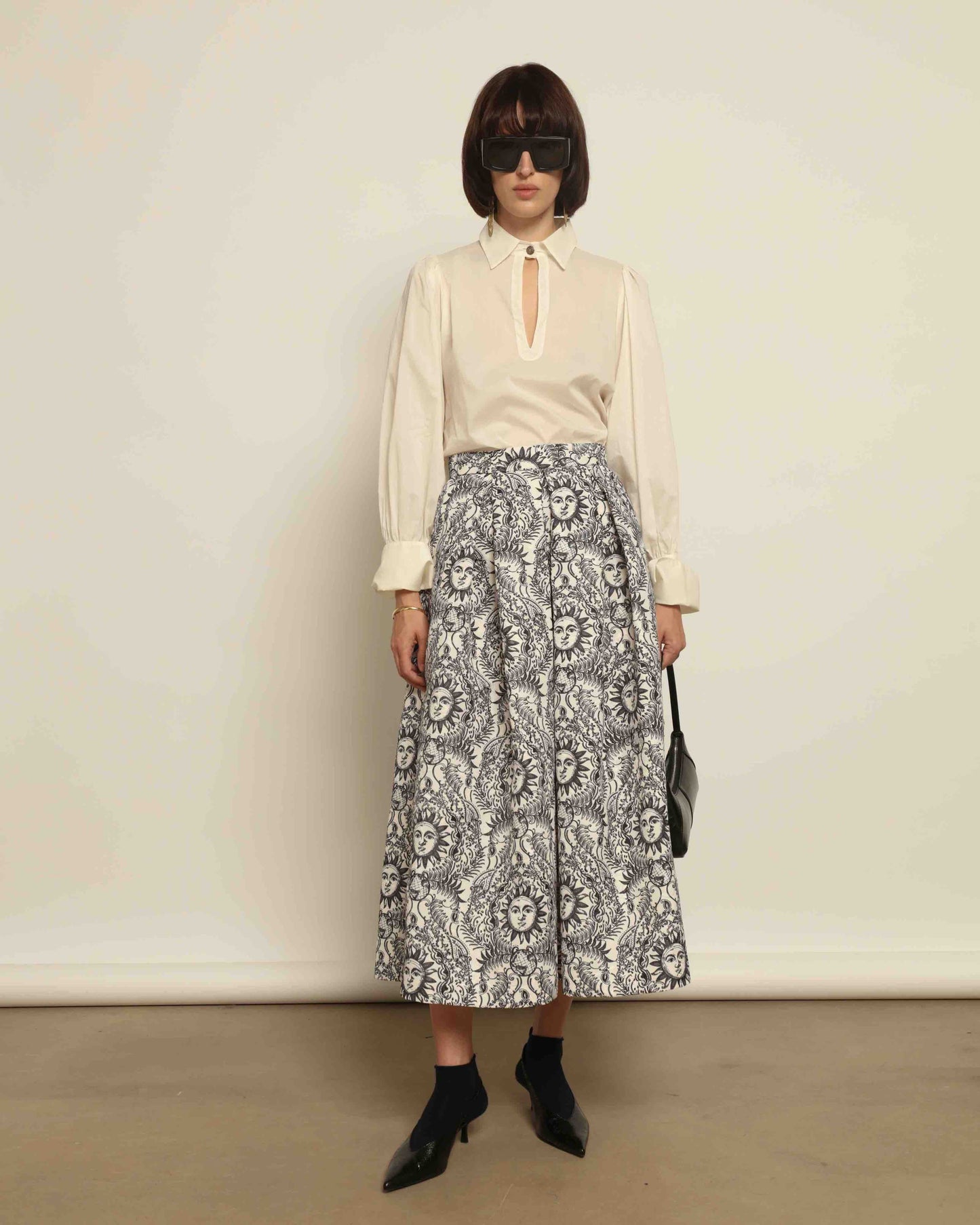 Model is wearing Sun Black and White Skirt by Lunatica Milano. Romantic floral skirt in classic black and white. Elegant, feminine, and handcrafted in Italy. Part of House of Woven Stories selection.