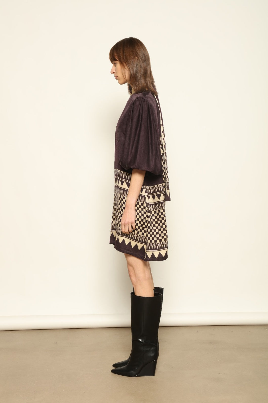 Model is wearing the Malaga Short Silk Dress with Belt by House of Woven Stories, hand-printed in Ajrakh silk with balloon sleeves and a waist belt.