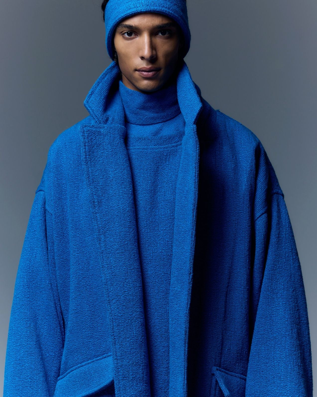 Model is wearing the French Blue Bouclé Blanket Coat by Marrakshi Life, a hand-woven oversized cotton bouclé coat with a deep shawl collar and textured finish, curated in the House of Woven Stories selection.