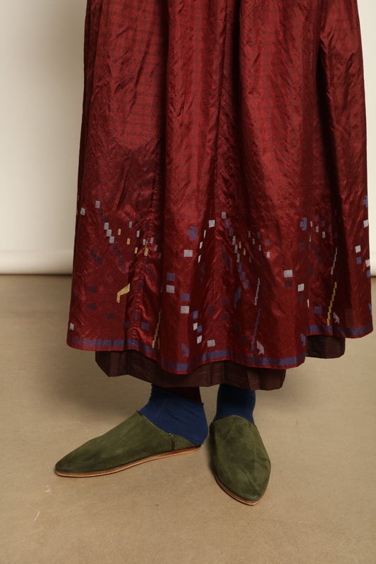 Model is wearing the Miraj 103 Silk Skirt by Injiri, handcrafted in red silk with vibrant rectangular motifs along the hem, blending artistry, movement, and refined elegance.