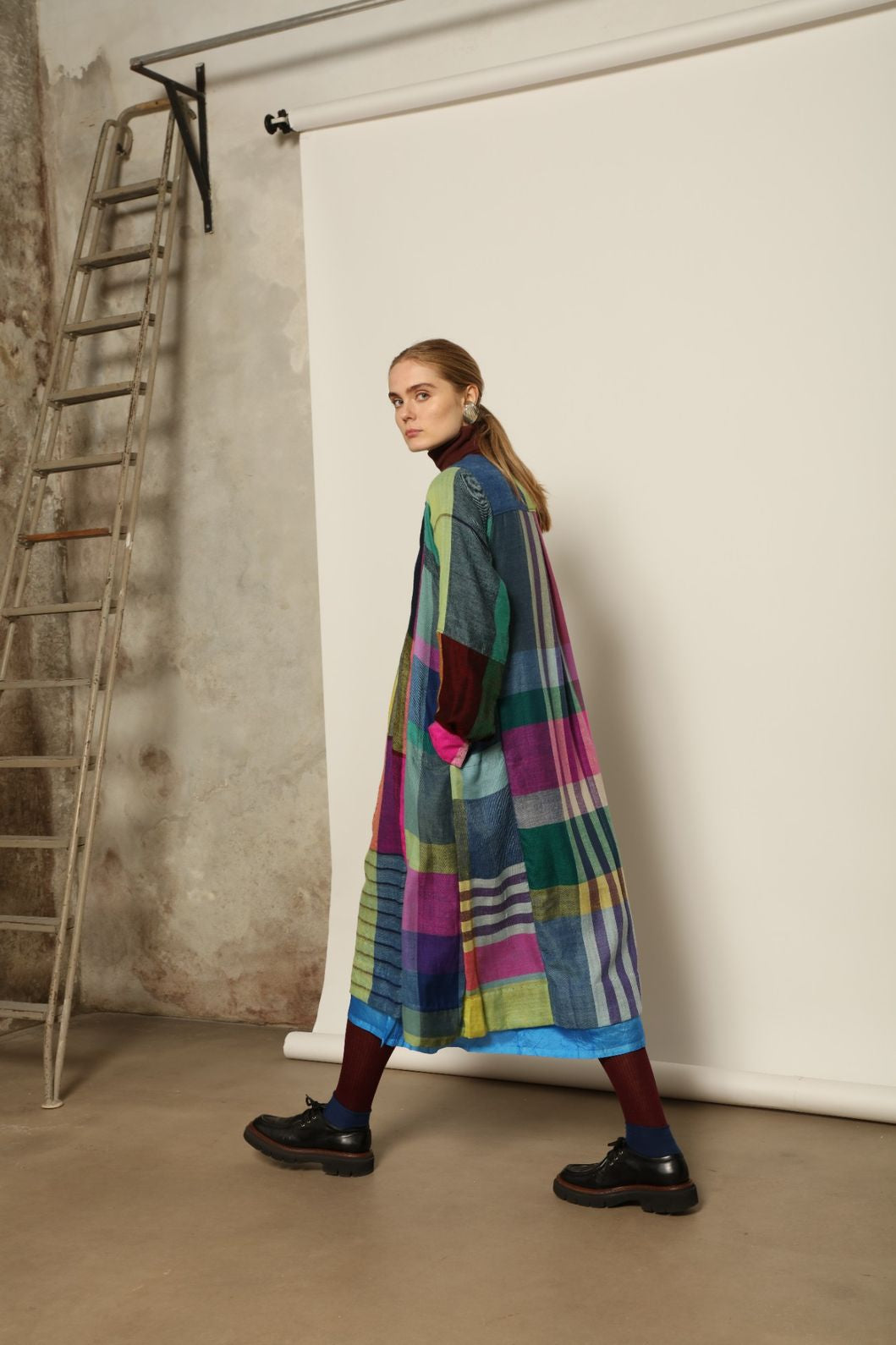 Model is wearing the Miraj 55 Pure Cashmere Dress by Injiri, crafted from the finest cashmere with bold multicolor check patterns, blending warmth, artistry, and refined elegance.