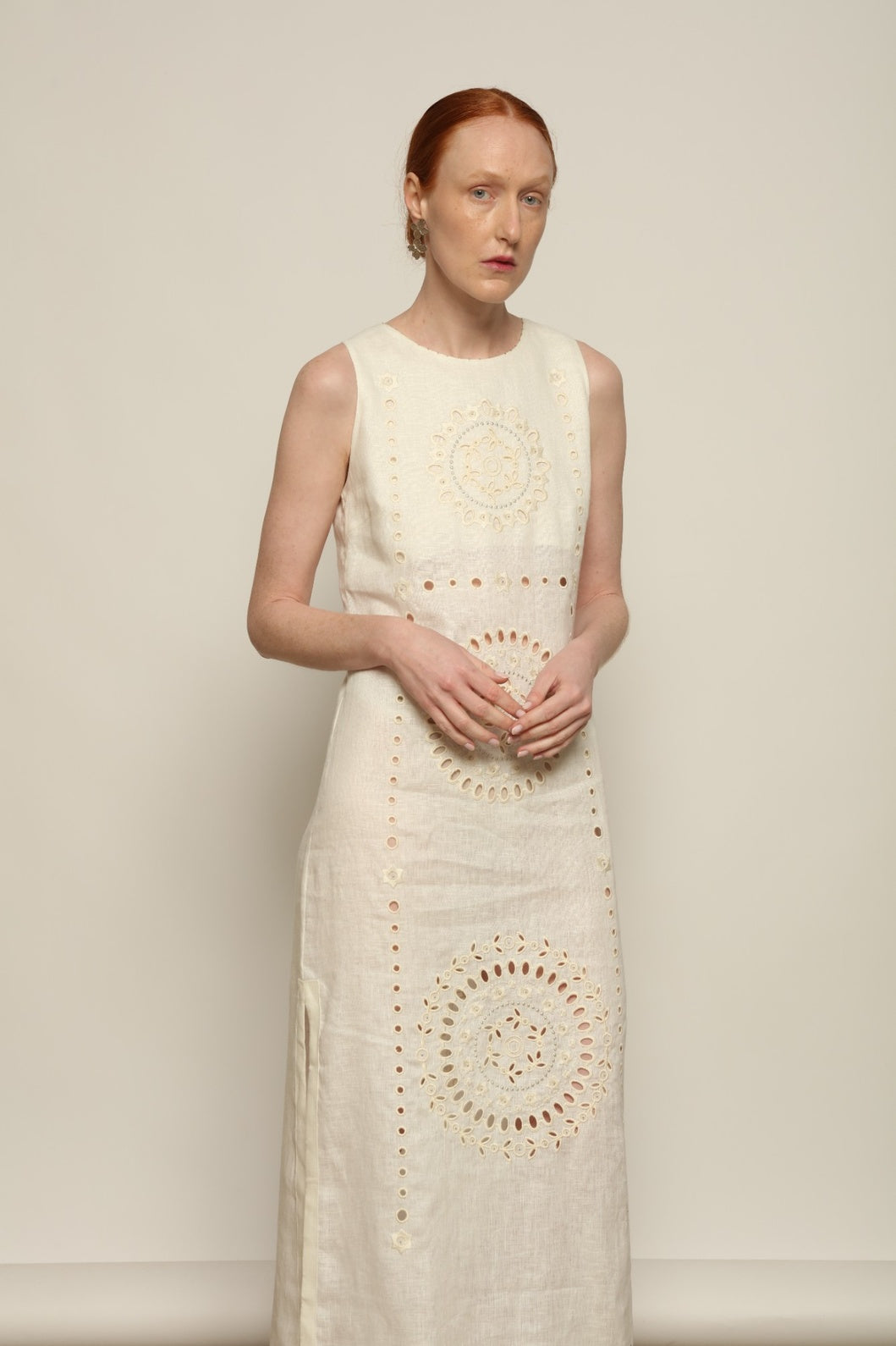 Model is wearing the My Sleeping Gypsy Champenois Dress, an ivory linen dress with hand-cut lace, delicate embroidery, and 24-carat bead accents, from the House of Nomad Stories selection.
